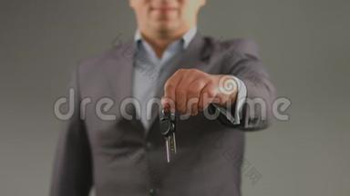 男人拿着车上的钥匙，公寓里的钥匙。 驾驶课程，彩票中奖